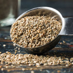 Spoon filled with seeds on a wooden surface